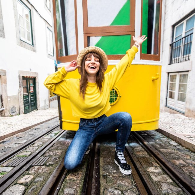 Woman tourist with famous yellow funicular tram of Lisbon, Portugal