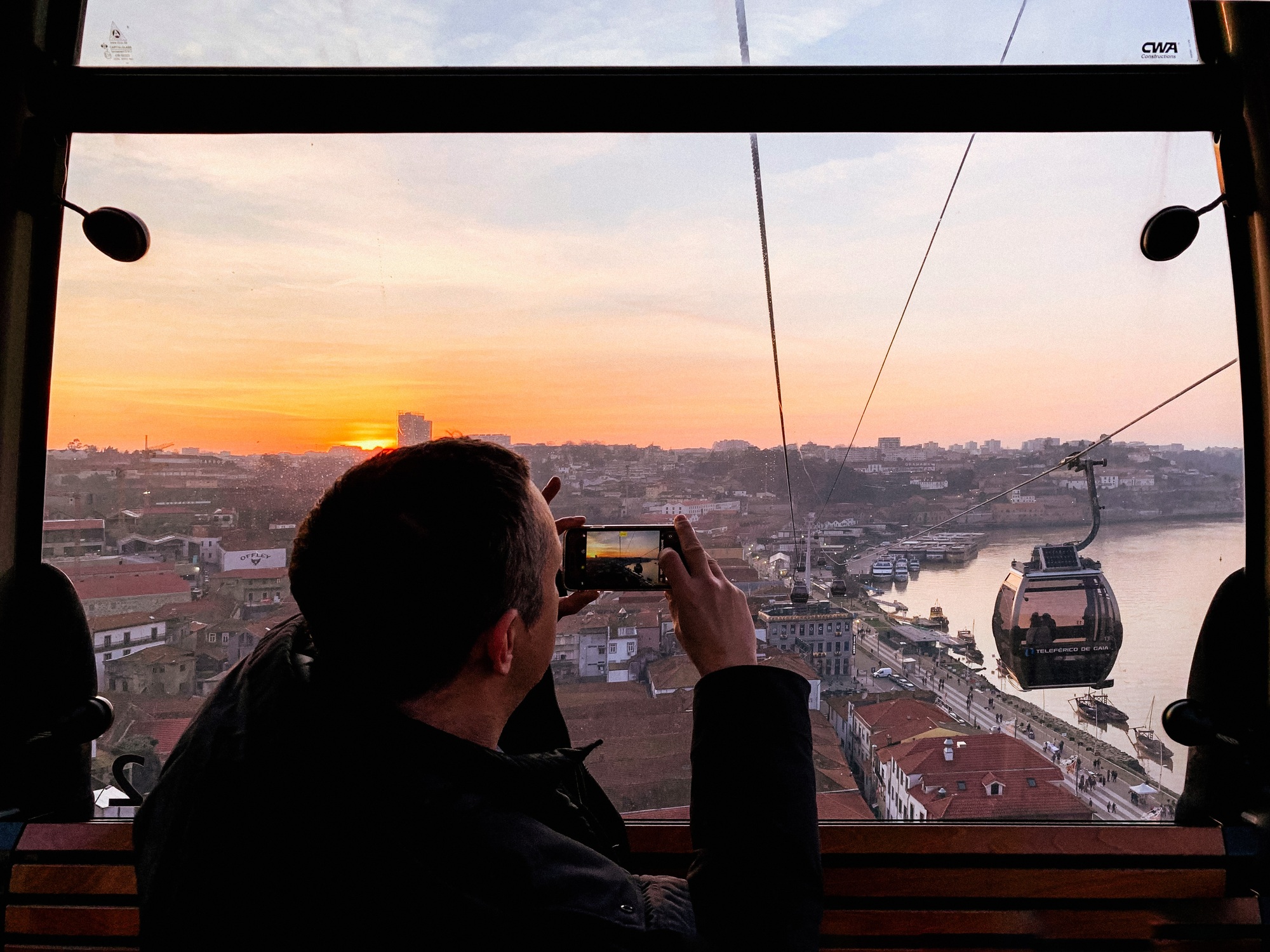 Young man making photo, story or video for his social media about using cable car in Porto, Portugal